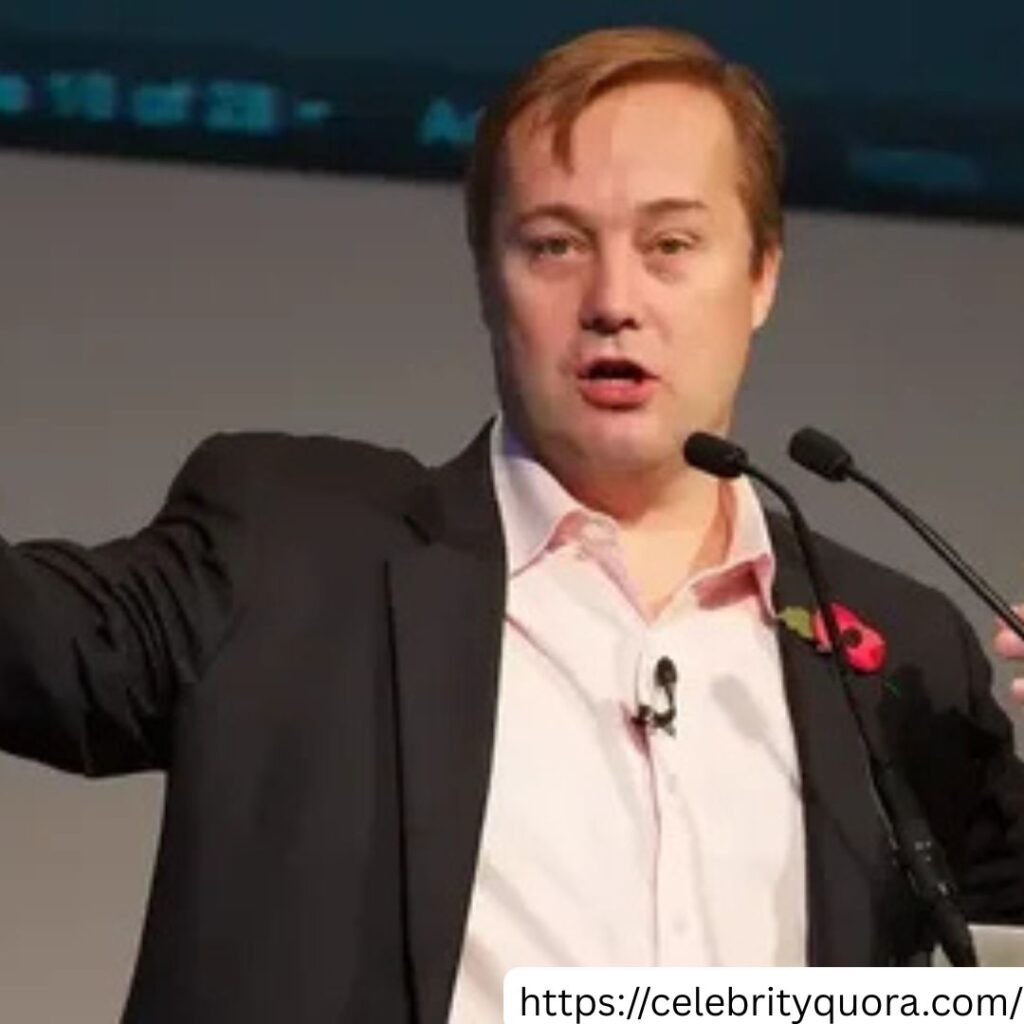 A man who appears to be Jason Calacanis is shown speaking at an event, wearing a suit.