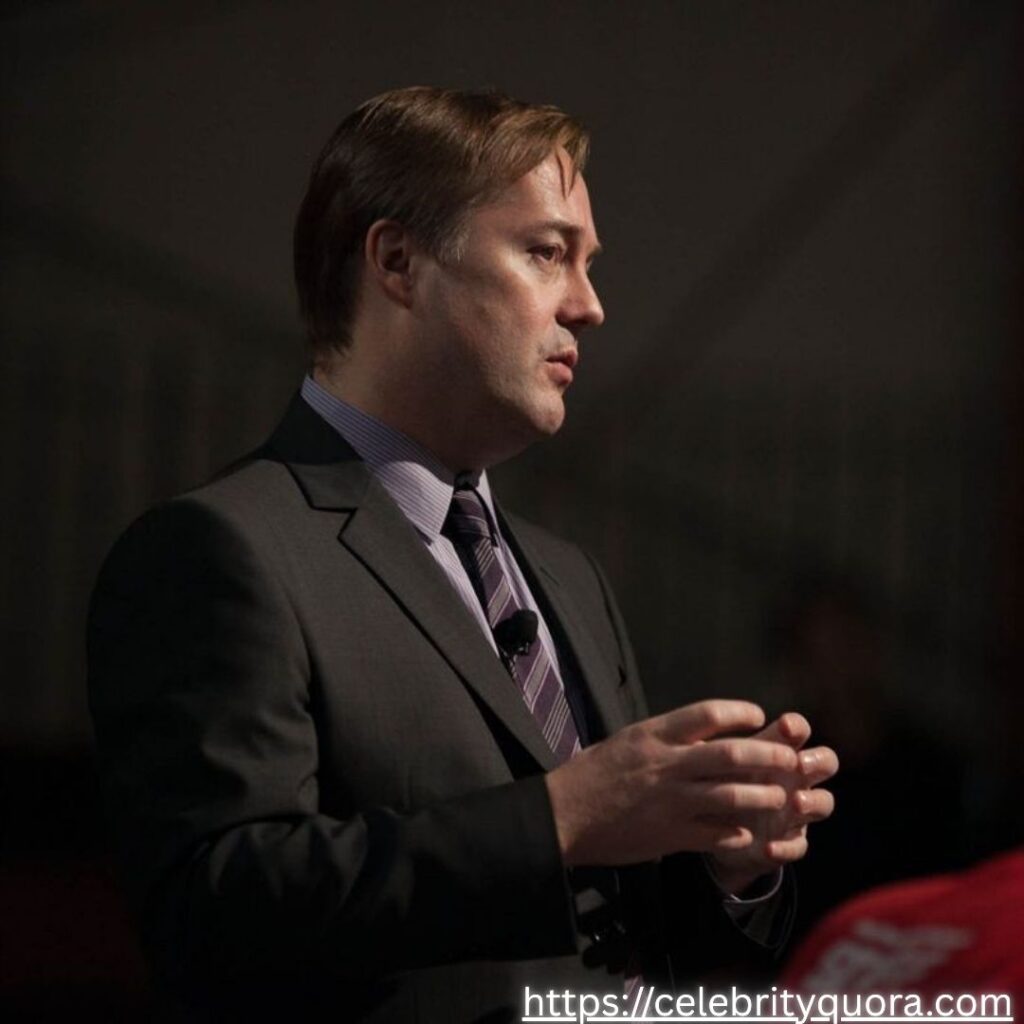  A man who appears to be Jason Calacanis is shown in a suit, possibly speaking at an event.