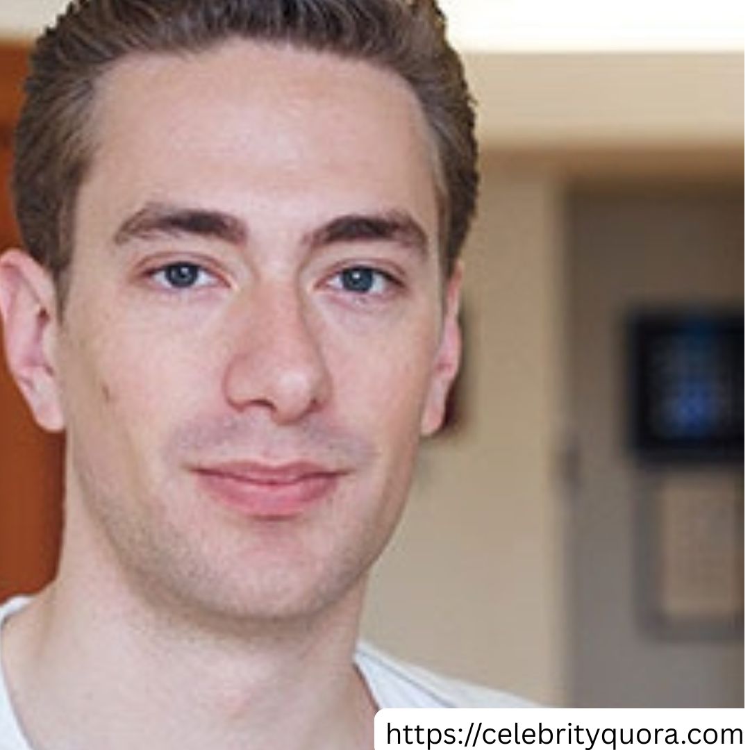 Purple Gradients Beauty and Skincare Product Feature Instagram Post (25) A close-up portrait of James Charles, a young man with light skin, light brown hair, and blue eyes. He is looking directly at the camera with a slight smile. He appears to be wearing a white shirt. The background is blurry, but suggests an indoor setting.