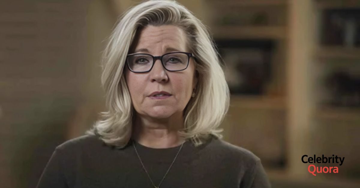  A focused portrait of Liz Cheney, featuring her distinctive blonde hair and black glasses, conveying a thoughtful demeanor.