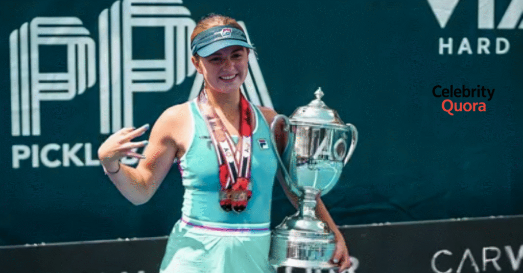 Anna Leigh Waters smiling and holding a large trophy with medals around her neck after a victory at a pickleball tournament.