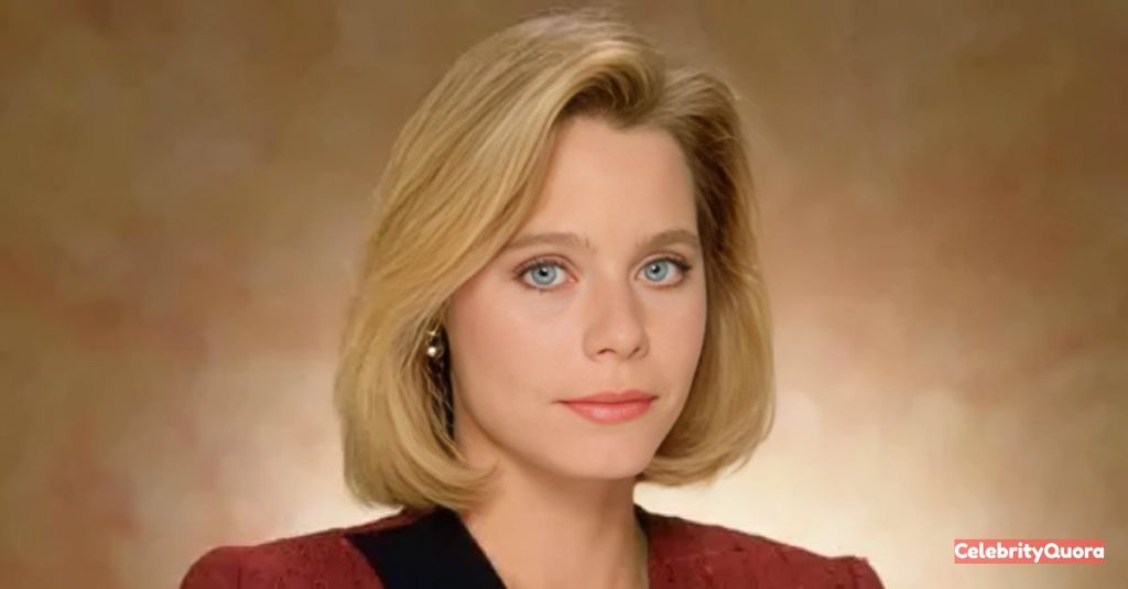 An official portrait of actress Susan Dey with a shoulder-length blonde bob. She is wearing a red blazer and a black top, looking directly at the camera with a neutral expression.