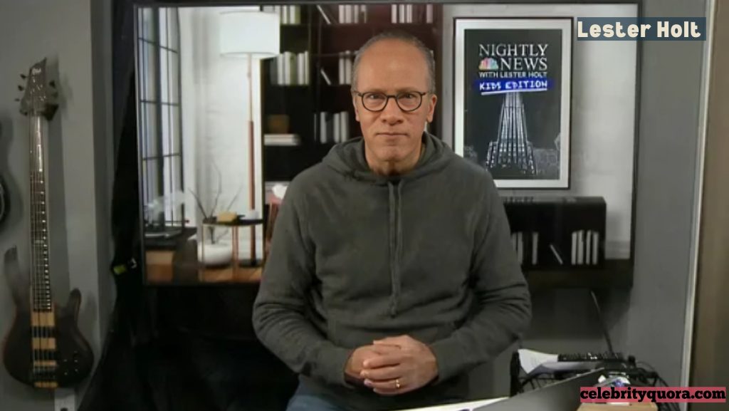 A casual image of Lester Holt wearing a gray hooded sweatshirt, seated in an interior space with a bass guitar visible on the left.